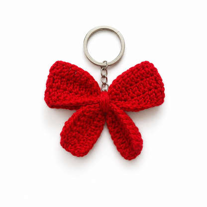 A bright red crocheted bow keychain with a silver metal split ring and chain, shown on a plain white background.