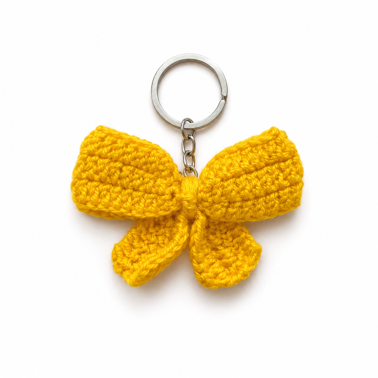 A bright yellow crocheted bow keychain with a silver metal split ring and chain, photographed on a clean white background.