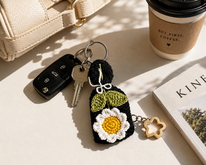 Handmade daisy crochet bag charm and keyring styled with everyday accessories