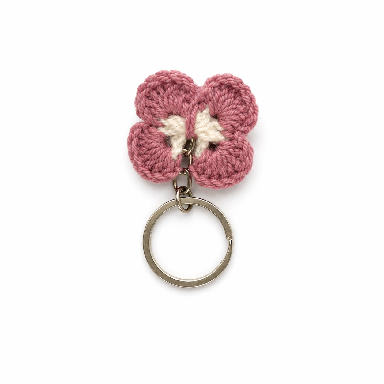 A pink crocheted flower keychain with a cream-colored center and a silver metal key ring, shown on a plain white background.